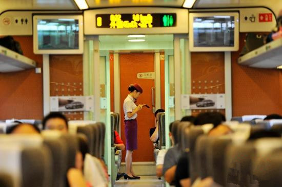 资料图:2014年8月8日,兰渝铁路高南线开通运营。图为D5176次动车乘务员为旅客服务瞬间。 安源 摄 资料图:2014年8月8日,兰渝铁路高南线开通运营。图为D5176次动车乘务员为旅客服务瞬间。 安源 摄