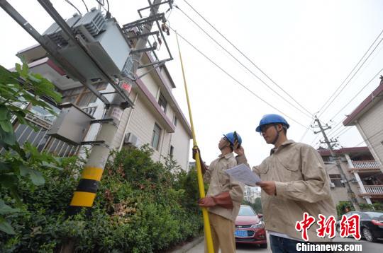 电力工作人员通过“小艾”核准相关信息为扬州经圩小区2号变压器送电。 寒单 摄
