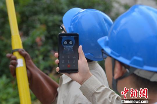 电力工作人员通过“小艾”核准相关信息为扬州经圩小区2号变压器送电。 寒单 摄