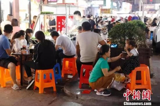 民众在小上海步行街品尝美食。 殷立勤 摄