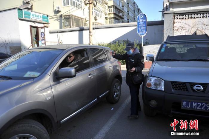 北京市某停车场管理员为车主指挥倒车。<a target='_blank' href='http://www.chinanews.com/' >中新网</a>记者 金硕 摄
