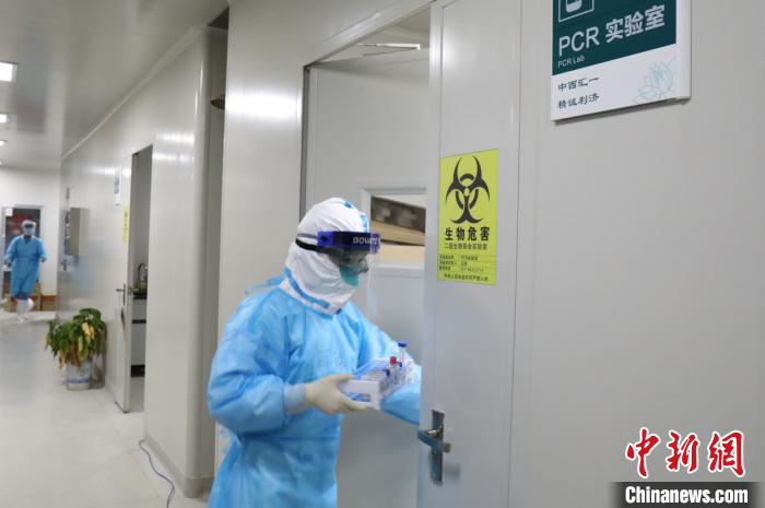 图为核酸检测员何静带着灭活后的样本进入PCR实验室 代雨朦 摄
