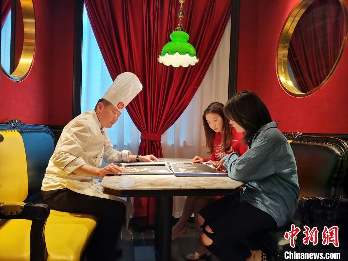 5月24日，记者在济南一鲁菜馆见到网络主播李頔时，她正在餐馆中向厨师了解当天所要进行“吃播”的鲁菜菜式、文化及用料选材方面的讲究。 郝学娟 摄