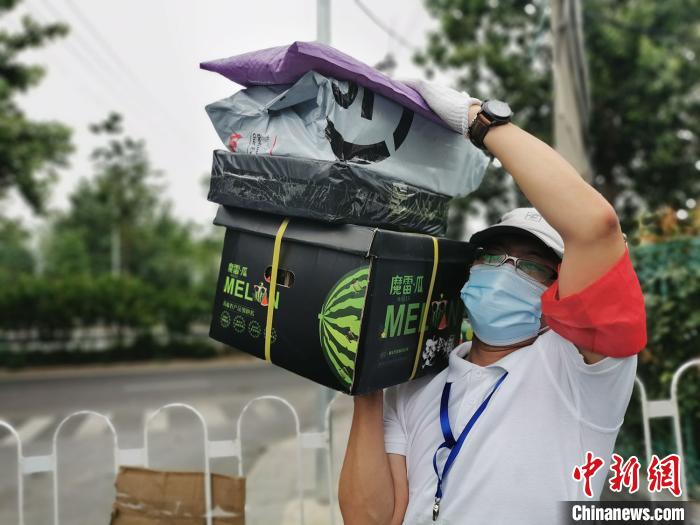 中建二局安装公司下沉干部岳晓剑为居民搬运物资。 中建二局供图 摄